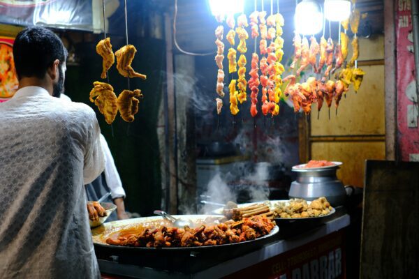 a vendor making food on a large skillet in India